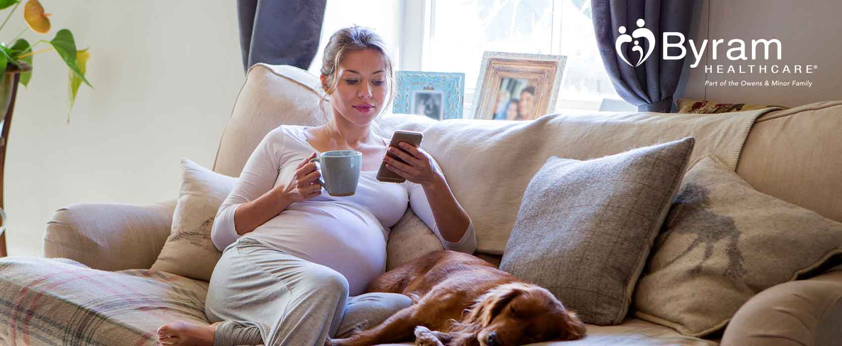 Mujer en un sillón con un smartphone y una taza de café
