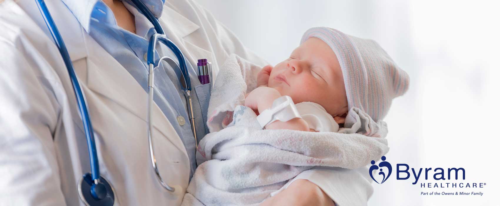Un médico sosteniendo en brazos a un recién nacido.