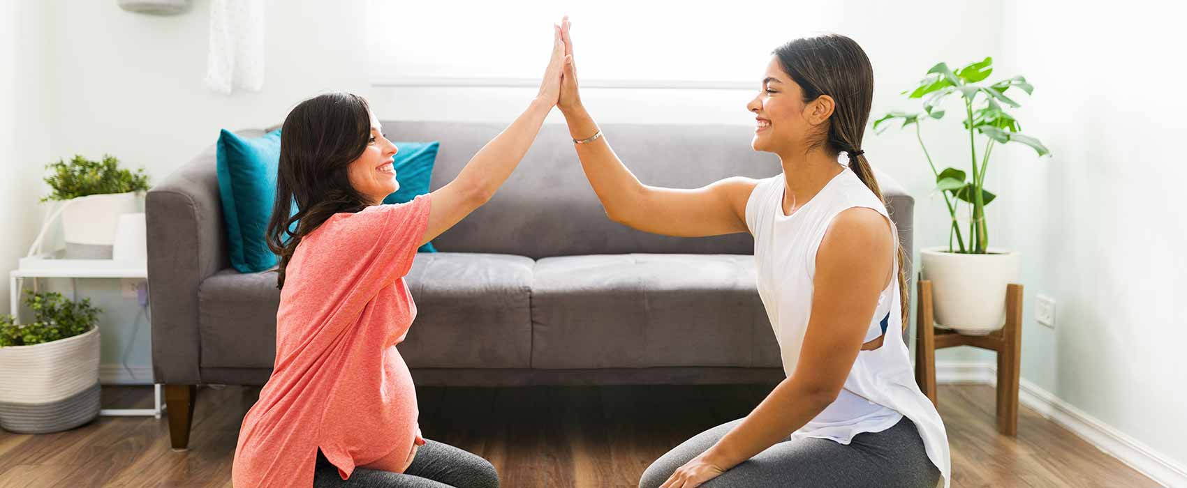 Pregnant woman high-fiving her doula.