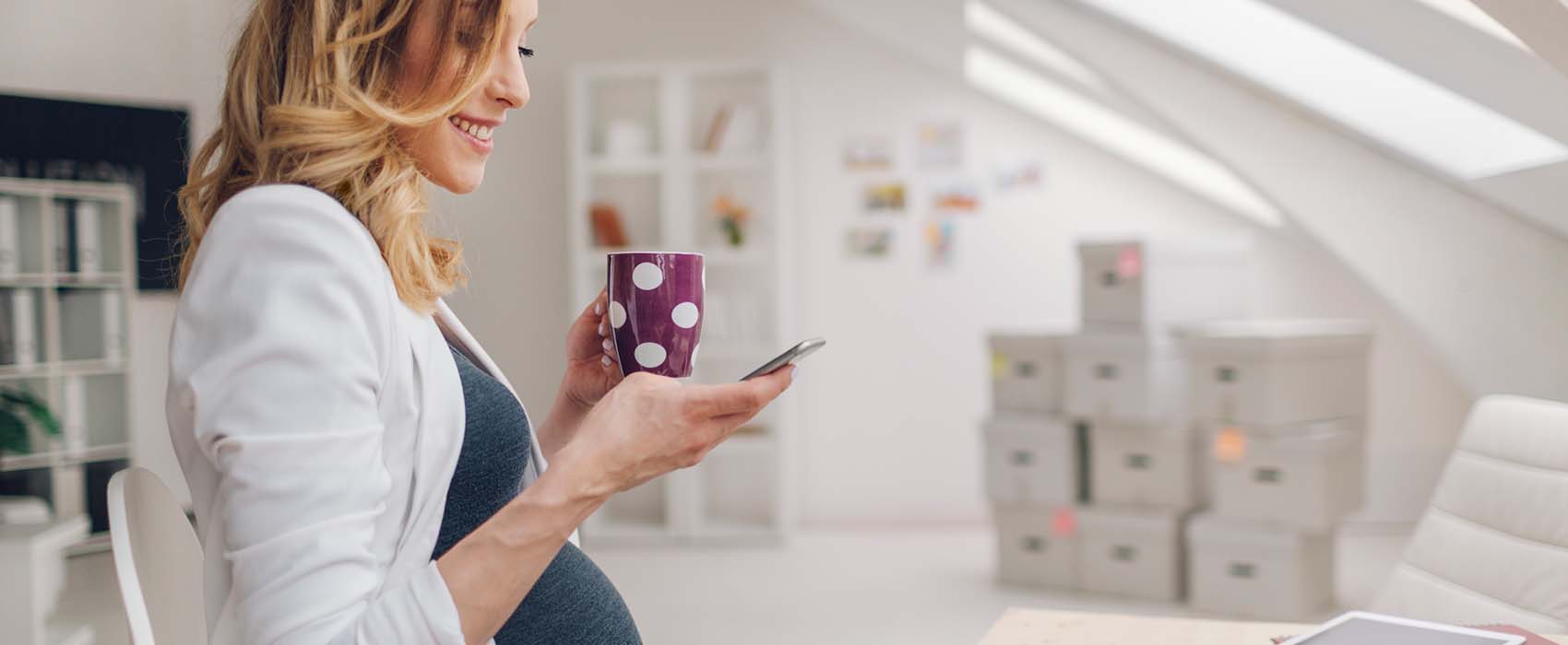 Woman looking at breast pump accessories on her phone. 