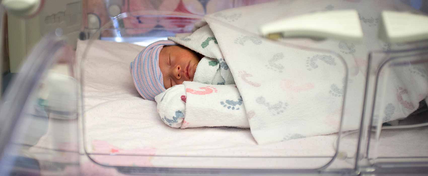 Bebé durmiendo en una unidad de cuidados intensivos neonatales (UCIN).
